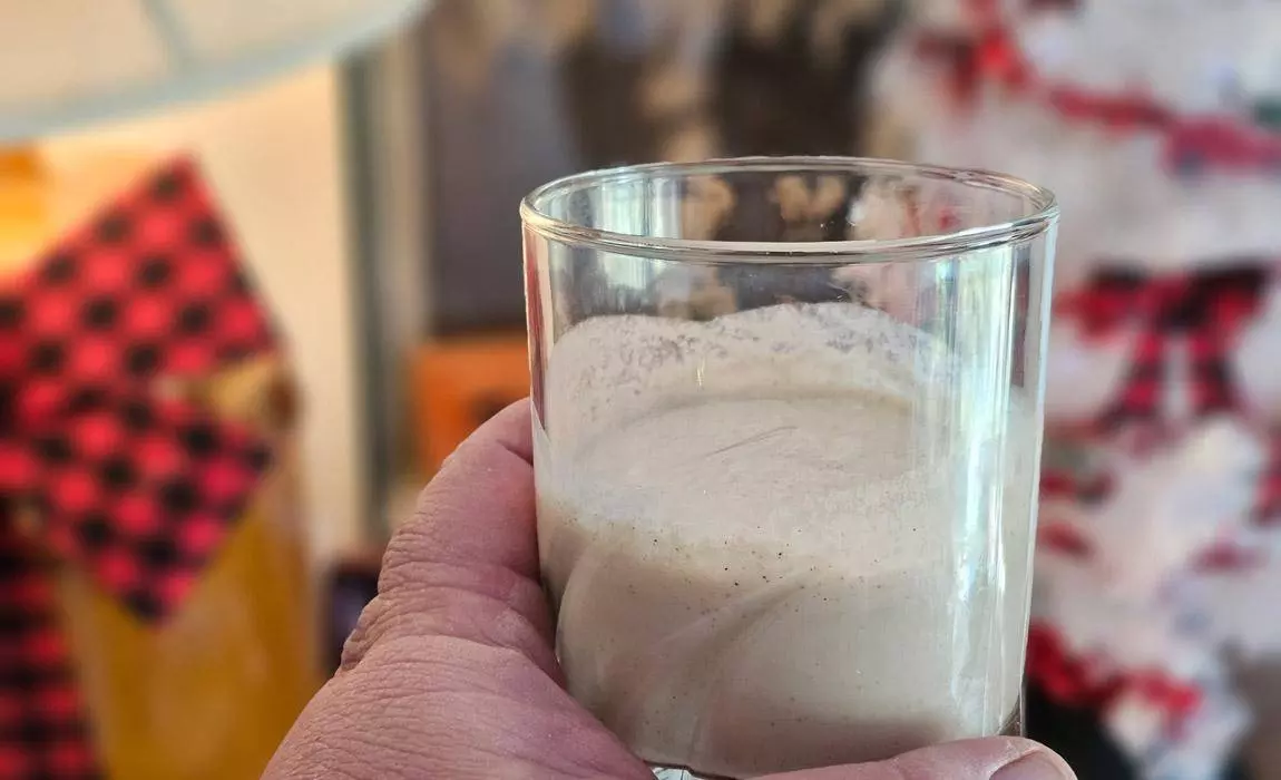 holding a glass of homemade coquito - some call this Puerto Rican eggnog