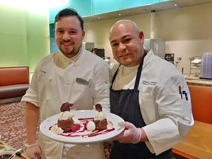 chefs presentign volcano cake desert