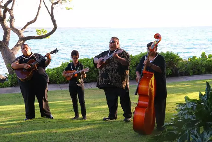 band welcoming guests to mauna kea luau