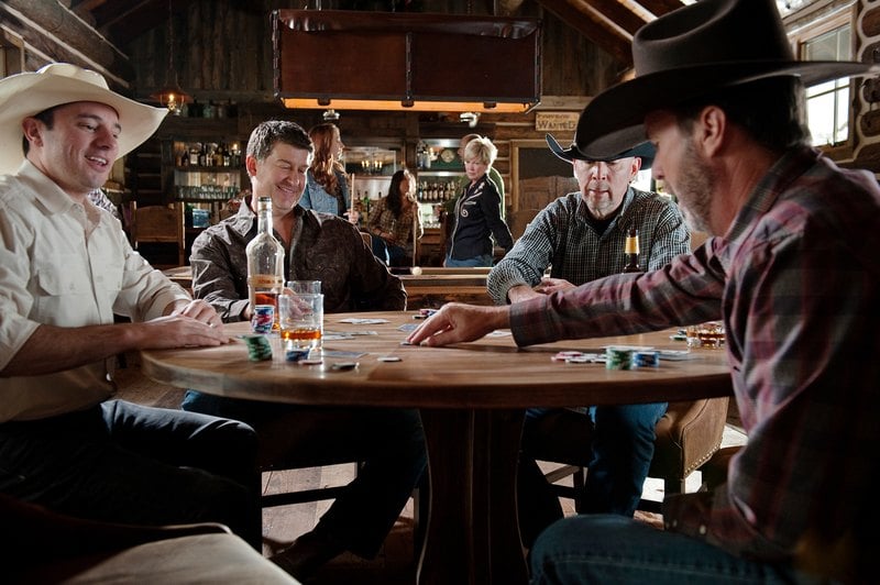 Men in cowboy hats playing poker at the saloon at Brush Creek Ranch, Wyoming