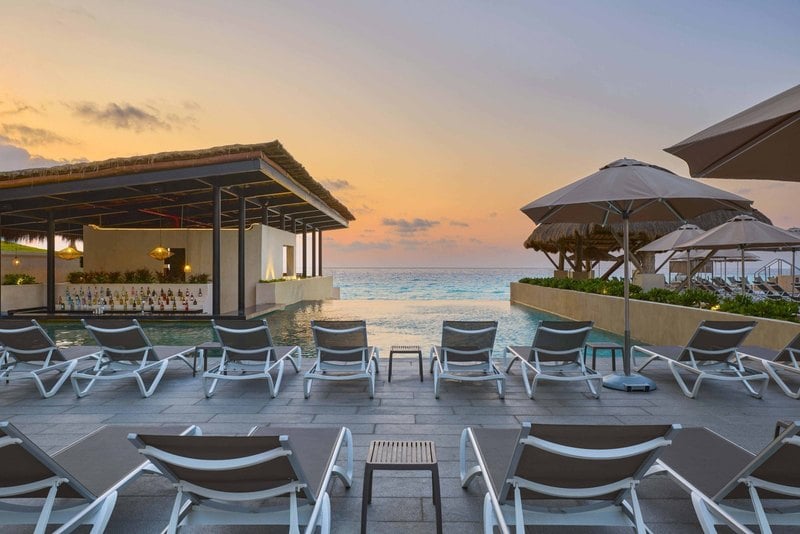 Adult pool and swim-up bar at sunset at Marriott Cancun, An All-Inclusive Resort