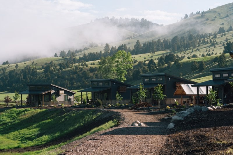Cabins below misty hills at The Meadows on Rock Creek guest ranch, Montana