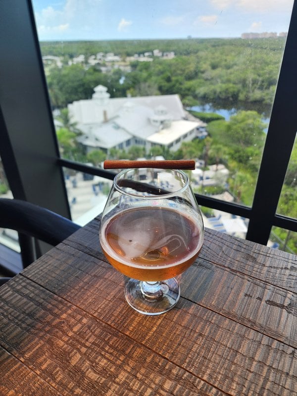 Crimson Orchid cocktail in a snifter overlooking Naples, Florida