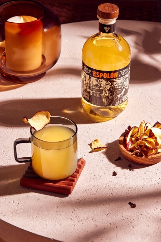 Espolòn Cider Season hot cocktail in a glass mug with apple chips