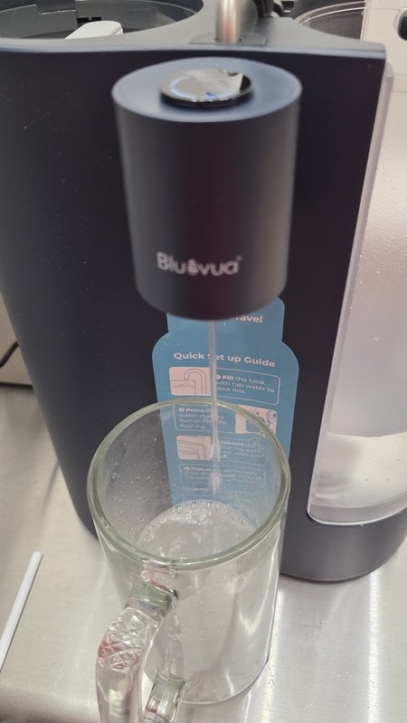 Bluevua ROPOT-Travel dispensing filtered water into a glass carafe