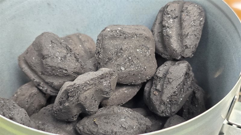 Kingsford Original charcoal briquettes stacked in a chimney starter showing their uniform pillow shape