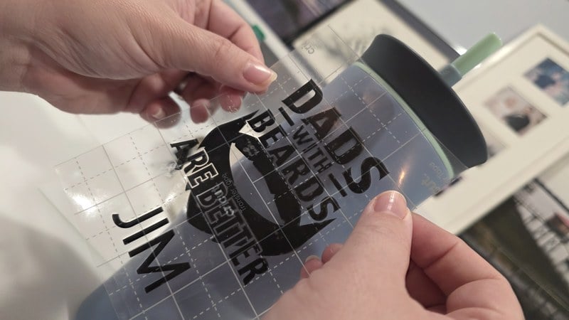 applying the cut vinyl decal to the mug with transfer tape