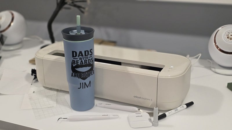 the finished custom Father's Day mug in front of the Cricut Explore 5 and its tools