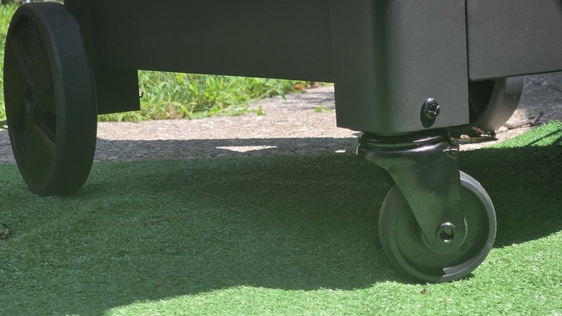 The fixed rear wheel and the plastic swivel caster on the cart of the Current Model G2 electric grill