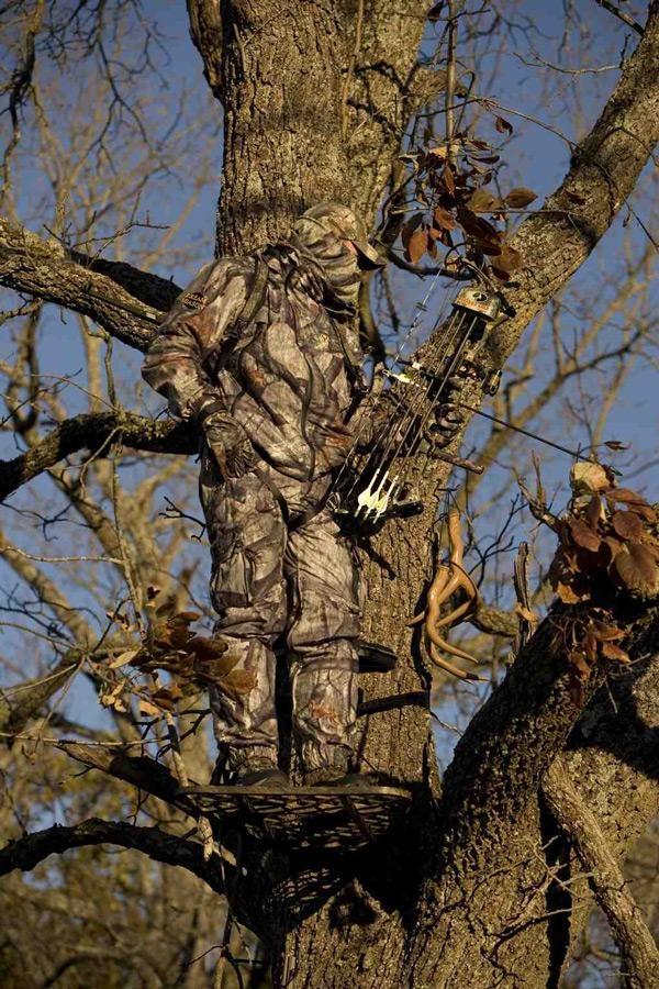 bow hunter standing in tree stand hunting deer