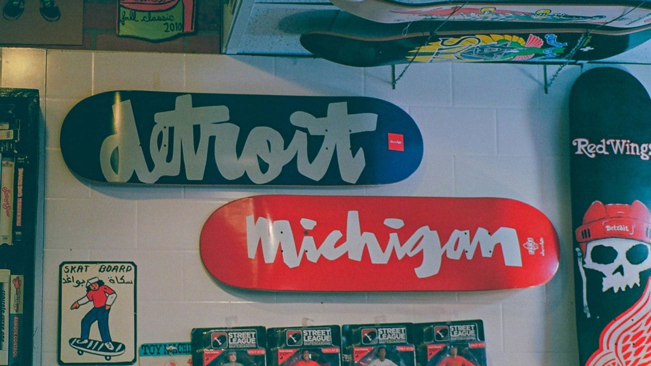 Detroit guys trip - Detroit and Michigan script-art skate decks alongside Red Wings memorabilia at a Detroit skate shop