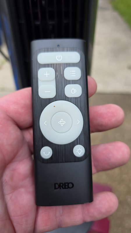 The Dreo TurboCool 711AS remote with its carbon fiber look finish, oscillation pad, and misting button