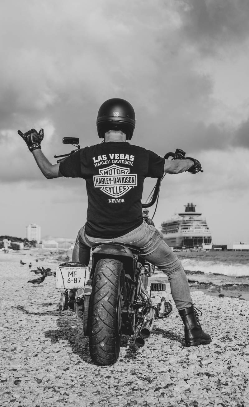 man riding harley motorcycle on beach