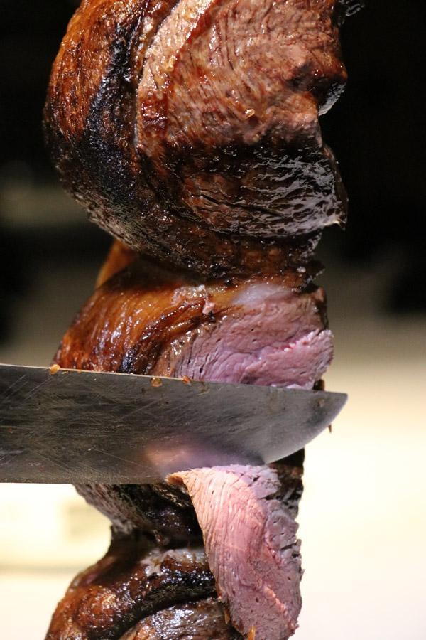 slicing picanha steak at fogo de chao