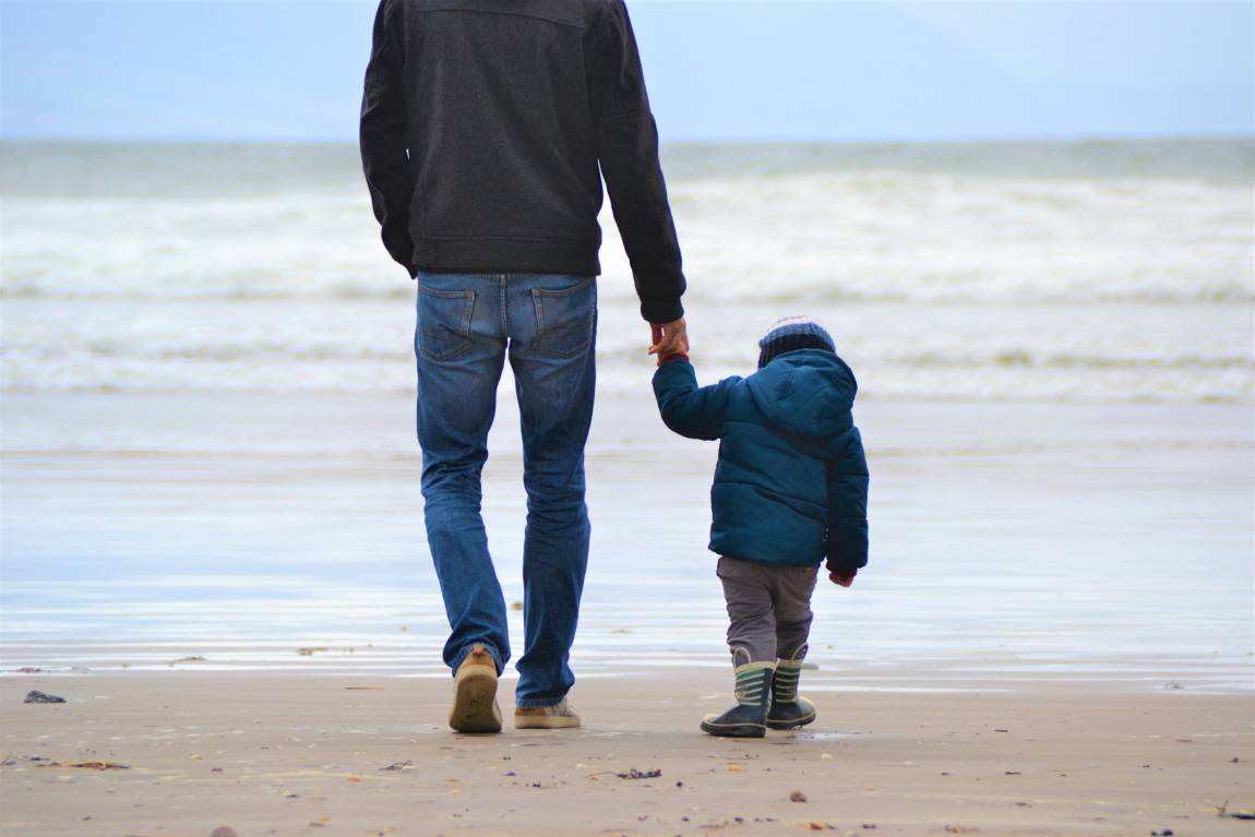 father and son weekend hike on the beach