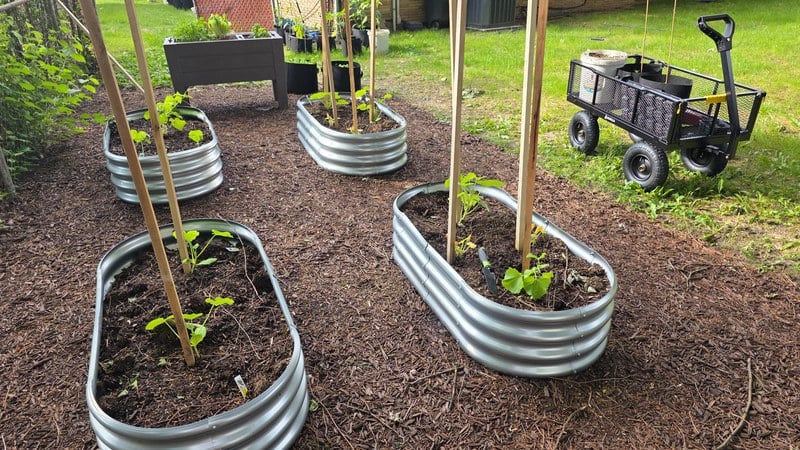 The Gorilla GCG-1200 utility cart parked among galvanized raised garden beds