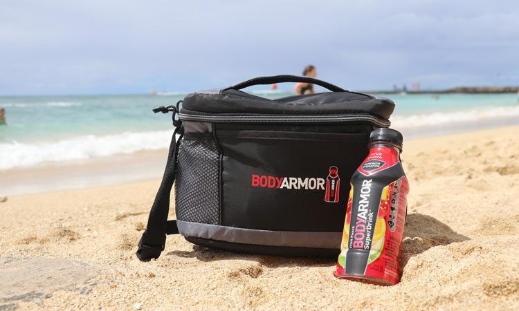 bodyarmor fruit punch and bag on beach