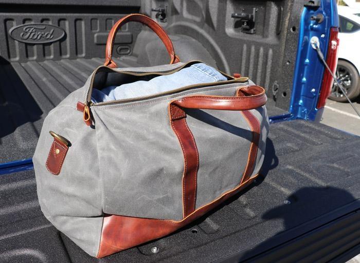 weekend bag open on back of truck bed