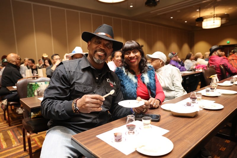 Guests seated with tasting glasses at a chef demonstration during the Kalahari Food and Wine Festival, several wearing cowboy hats