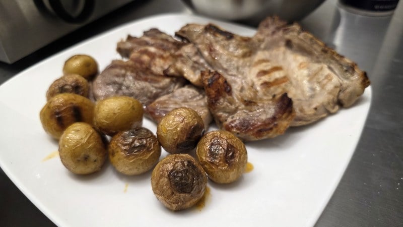 Grilled pork chops and grilled baby potatoes plated after cooking on the Kenyon City Grill