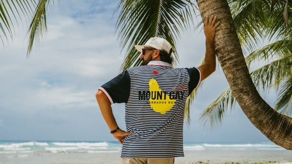 Navy and white striped Bridgetown Polo with the yellow Mount Gay Barbados Rum back graphic