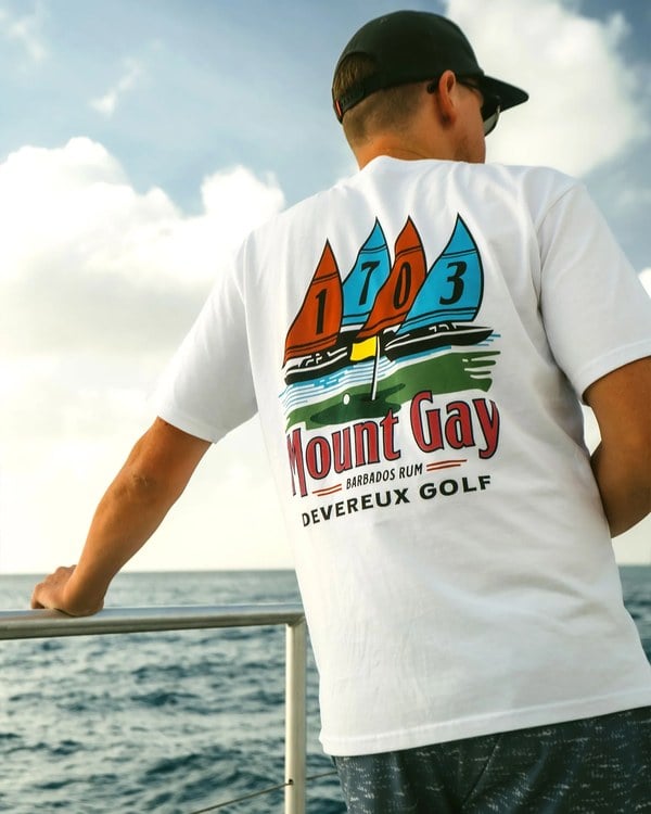 White Regatta Tee with the Mount Gay x Devereux Golf sailing graphic, worn on a boat