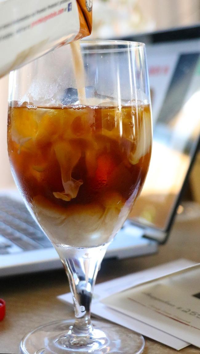 pouring carmel premier protein into iced coffee 2