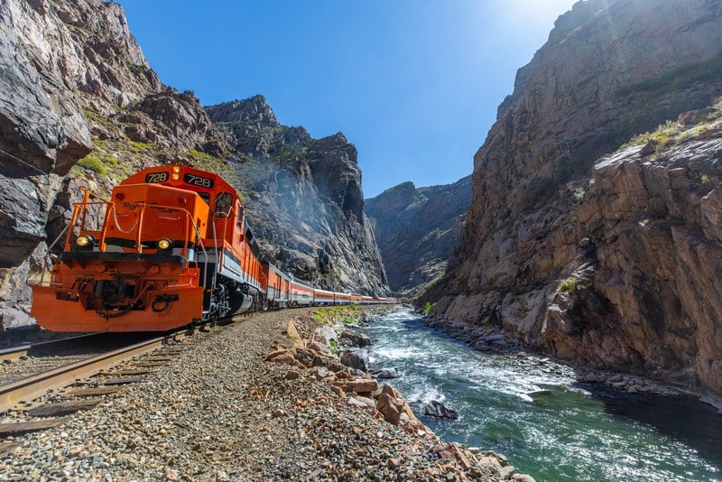 Royal Gorge Route Railroad locomotive 728 at track level in the canyon with the Arkansas River alongside