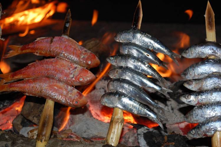 fish roasting on skewers over fire costa del sol spain