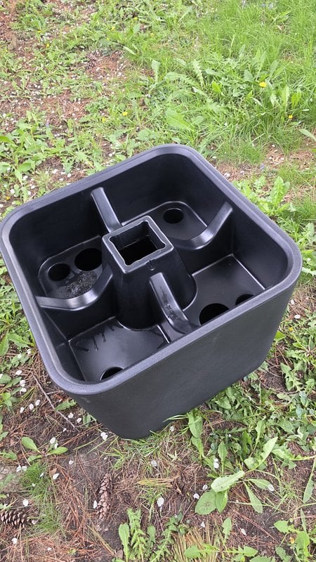 Empty Step2 Firefly planter base from above showing the central 4x4 post slot and surrounding drainage holes