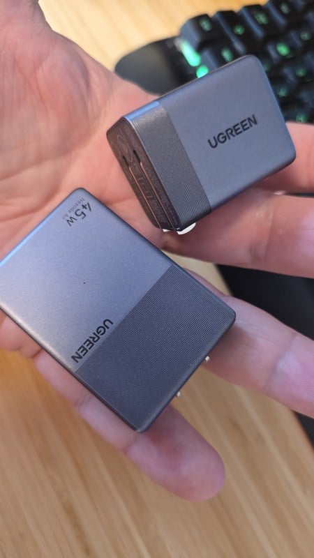 The UGREEN Nexode Air Slim 45W and the Nexode Air 65W cube held together in one hand for size comparison