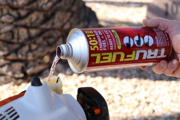 pouring trufuel into string trimmer