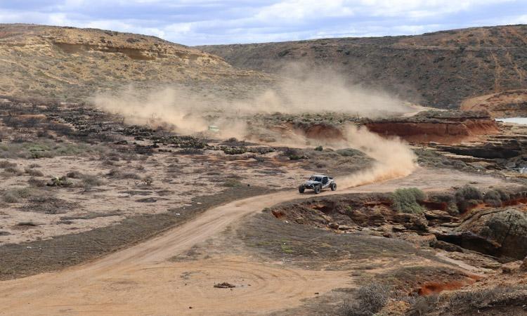 baja cars on dusty coastal road wide open baja