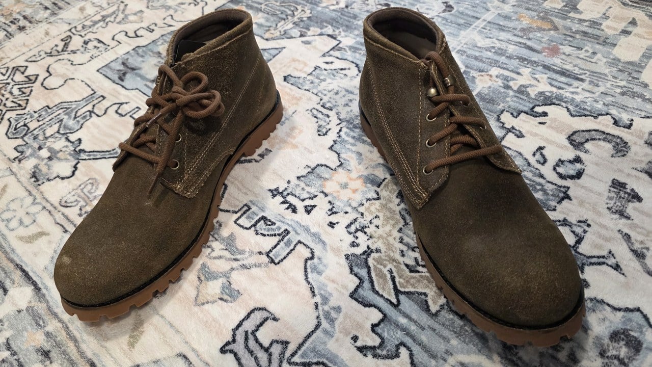 Wolverine 1000 Mile Legacy Cort Boot pair on a patterned rug, top-down view showing roughout suede chukka uppers with brown laces and rubber lug outsoles