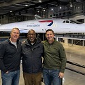 Three men standing in front of Concorde Alpha Foxtrot in the hangar at Aerospace Bristol