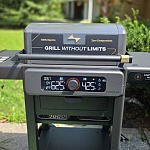 The Current Model G2 electric grill on its cart outdoors, display lit with both zones set to different temperatures