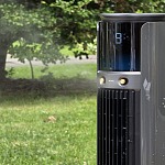 Dreo TurboCool 711AS outdoor misting fan running on a lawn with mist blowing across the yard