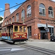 Cable car number 49 crossing in front of the San Francisco Cable Car Museum in the Washington and Mason powerhouse