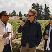 Three men tasting red wine among the vines at Chateau Pape Clement outside Bordeaux, France on a guys trip