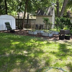 Midwest backyard water-wise garden with galvanized raised beds, container planters, and a natural lawn