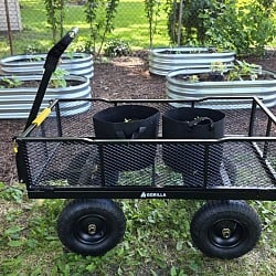 Gorilla GCG-1200 steel utility cart with grow bags in a backyard vegetable garden