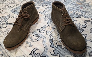 Wolverine 1000 Mile Legacy Cort Boot pair on a patterned rug, top-down view showing roughout suede chukka uppers with brown laces and rubber lug outsoles