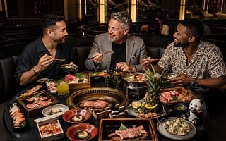 Three friends sharing hot pot, Korean BBQ and sushi during a Las Vegas guys trip in an upscale Asian restaurant
