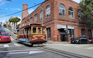 Cable car number 49 crossing in front of the San Francisco Cable Car Museum in the Washington and Mason powerhouse