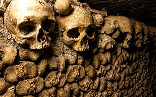 Wall of skulls and stacked bones in the Paris Catacombs ossuary