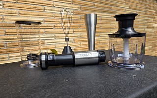 The FRESKO 4-in-1 immersion hand blender kit laid out on a table: measuring beaker with lid, whisk attachment, blending wand, motor body and the chopper bowl
