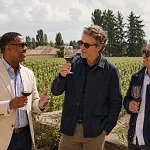 Three men tasting red wine among the vines at Chateau Pape Clement outside Bordeaux, France on a guys trip