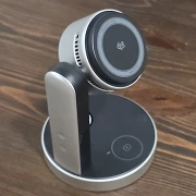 The UGREEN MagFlow Pro 3-in-1 wireless charging stand on a wood desk, its round Qi2 25W phone pad and side cooling vents facing the camera