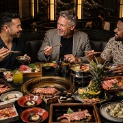 Three friends sharing hot pot, Korean BBQ and sushi during a Las Vegas guys trip in an upscale Asian restaurant