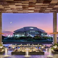 Clover Club lawn at Live! by Loews Arlington facing AT&T Stadium at dusk (photo credit: Loews Hotels)